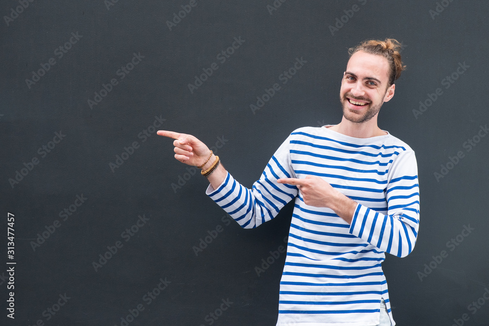 happy young man with beard pointing fingers to empty space on black background happy young man with beard pointing fingers to empty space on black background