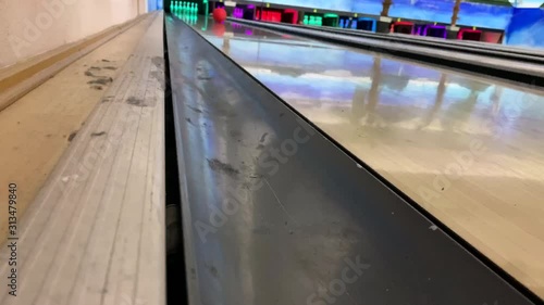 bowling ball rolls and knocks down pins