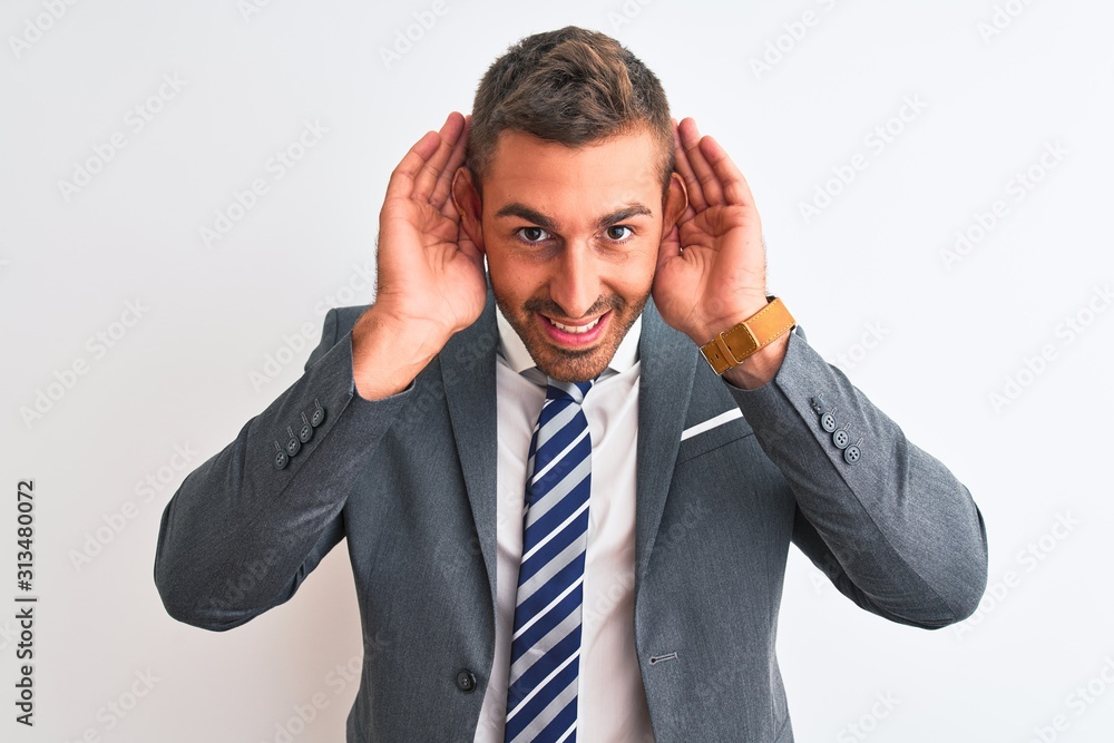 Young handsome business man wearing suit and tie over isolated background Trying to hear both hands on ear gesture, curious for gossip. Hearing problem, deaf Young handsome business man wearing suit and tie over isolated background Trying to hear both hands on ear gesture, curious for gossip. Hearing problem, deaf