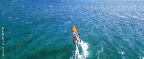 Aerial drone ultra wide photo of wind athlete surfer practising in deep blue open ocean sea