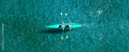 Aerial drone ultra wide photo of women practising sport canoe in tropical exotic lake with turquoise clear sea