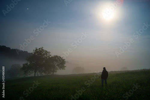 silhouette of a man under cloudy and foggy night
