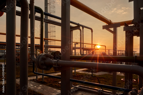 Gas industry. Pipeline system at gas processing plant illuminated by the rays of the rising sun photo