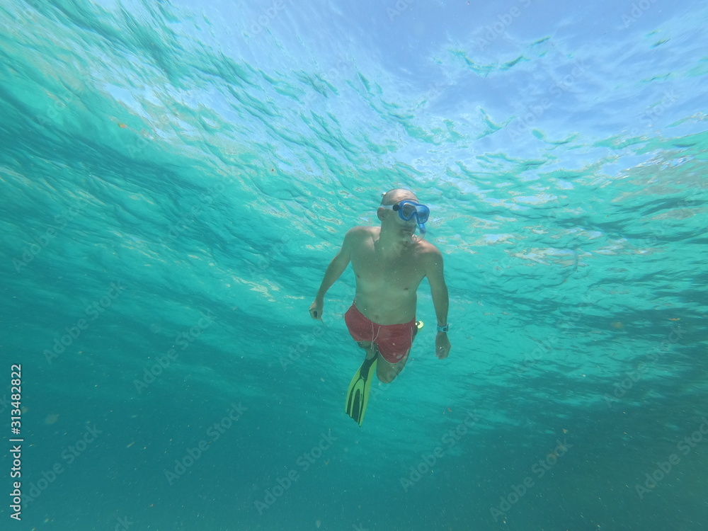 underwater man snorkeling in the sea withcrystal-clear waters concept of holiday relax summer beach diver in the sea