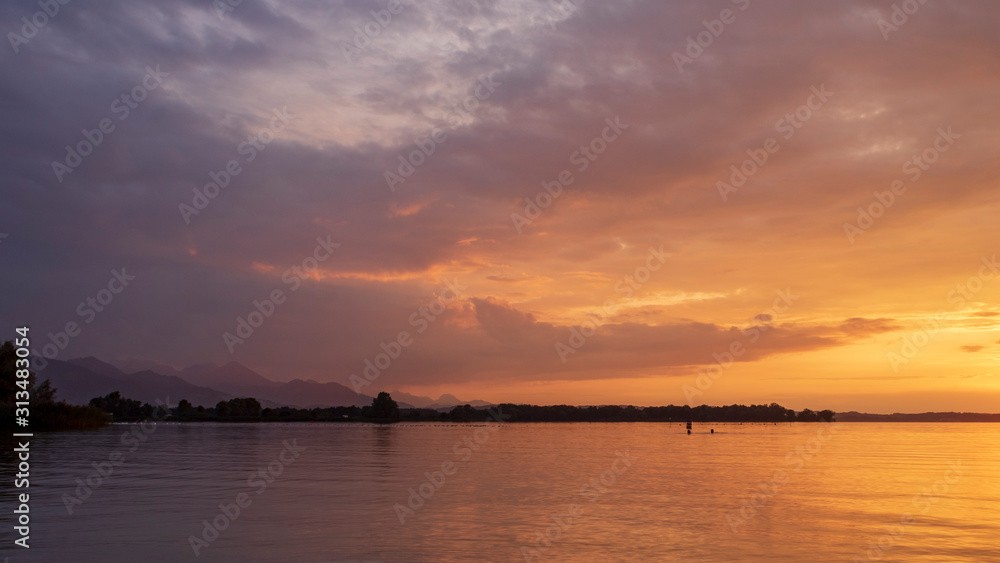 Sunset at lake Chiemsee against cloudy sky during golden hour