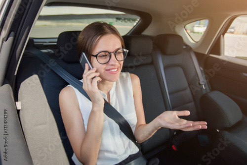 Young woman  with  gadget smartphone sitting in modern car © Oleksandr Kozak