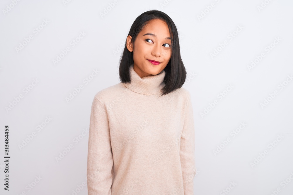 Young chinese woman wearing turtleneck sweater standing over isolated white background smiling looking to the side and staring away thinking. Young chinese woman wearing turtleneck sweater standing over isolated white background smiling looking to the side and staring away thinking.