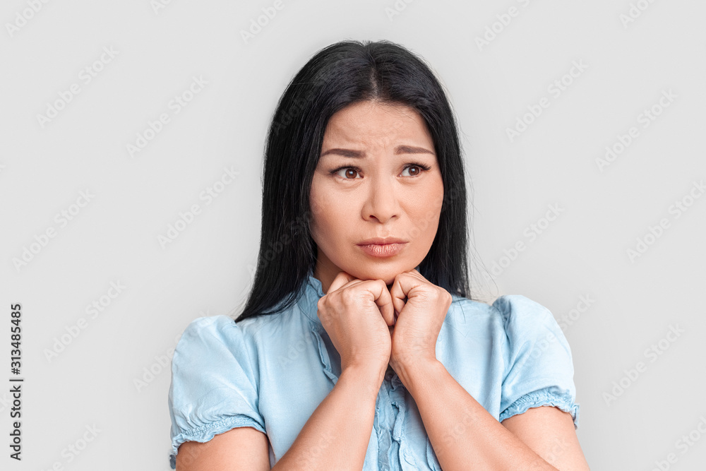 Freestyle. Asian woman standing isolated on white looking aside sad close-up Freestyle. Asian woman standing isolated on white looking aside sad close-up