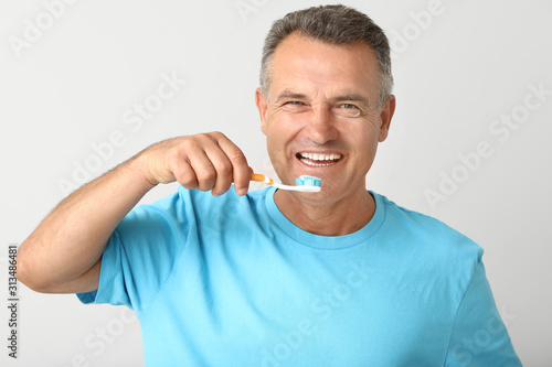 Mature man brushing teeth o...
