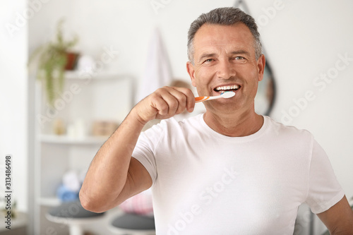 Mature man brushing teeth a...