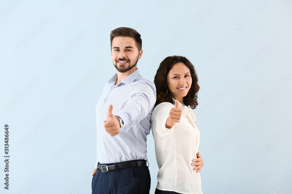 Portrait of young business people showing thumb-up gesture on color background Portrait of young business people showing thumb-up gesture on color background
