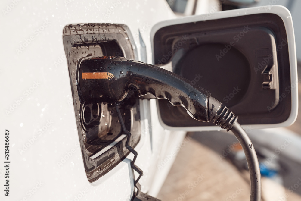 Tramsportation. Elcetric car closeup at charging station no people