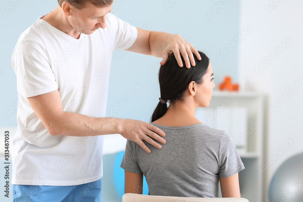 Obraz premium Physiotherapist working with female patient in rehabilitation center
