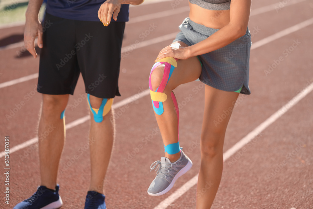 Sporty people with physio tape at stadium Sporty people with physio tape at stadium