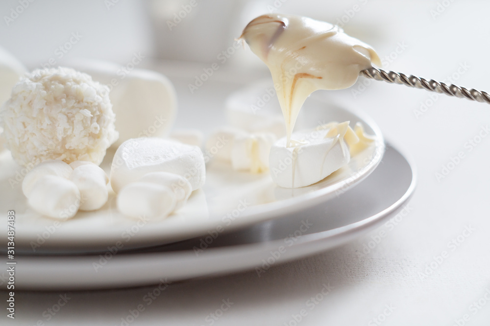 Various white candies, marshmallows and peanut butter on a light background Various white candies, marshmallows and peanut butter on a light background