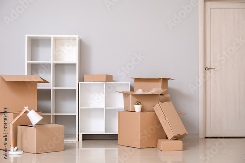 Cardboard boxes with belongings in new flat on moving day