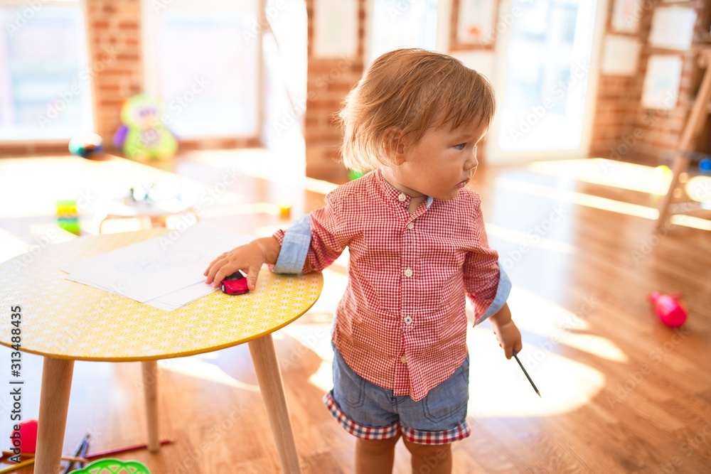 Adorable toddler playing around lots of toys at kindergarten - obrazy, fototapety, plakaty 