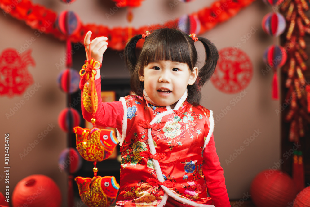 Chinese baby girl traditional dressing up hold a Fu means 'lucky' greeting sign Chinese baby girl traditional dressing up hold a Fu means 'lucky' greeting sign