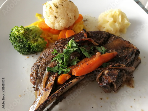 Kleftiko dish cuisine of Cyprus. Stewed lamb meat served with vegetables, herbs and mashed potatoes photo