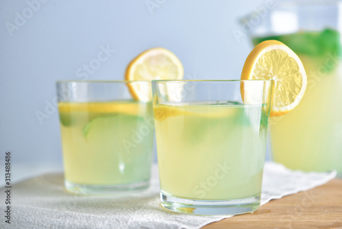 Glasses of tasty lemonade on table