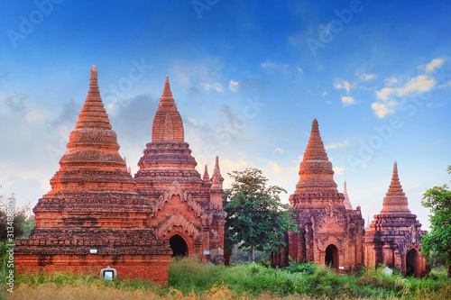 Blue sky above temples surrounded by green vegetation in old Bagan, Myanmar.