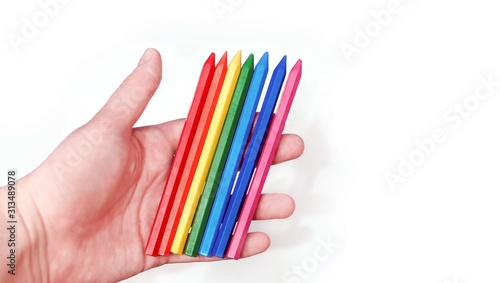 Colorful pencils in hand on white background