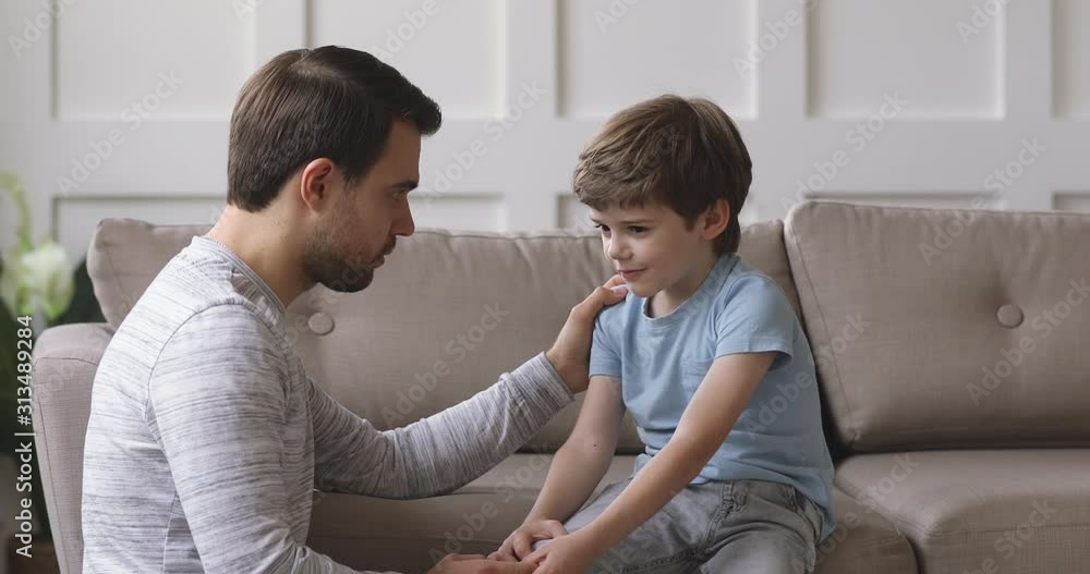 Caring single father comforting talking with kid son at home Caring single father comforting talking with kid son at home