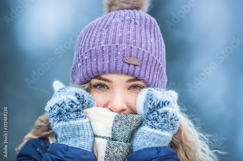 Portrait of young beautiful woman in winter clothes and strong frost.