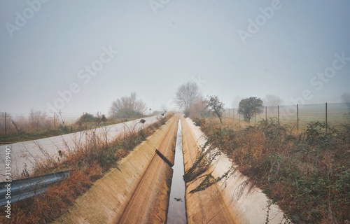 Autumnal landscape with irrigation water canal