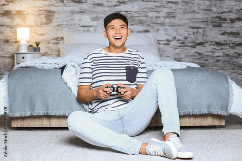 Asian man playing video gam...