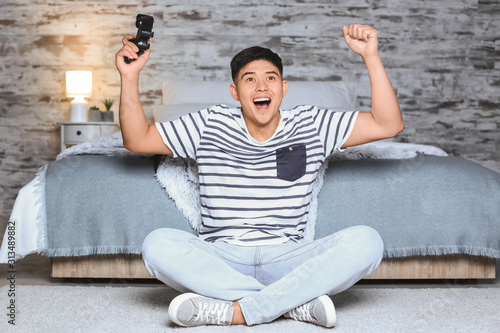 Asian man playing video gam...