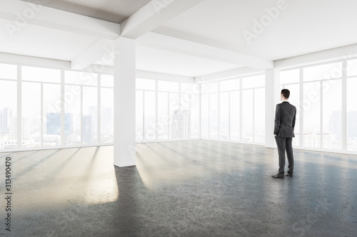 Young businessman standing in modern interior
