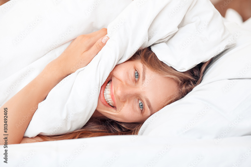 Morning at Home. Woman lying on bed under blanket laughing cheerful close-up Morning at Home. Woman lying on bed under blanket laughing cheerful close-up