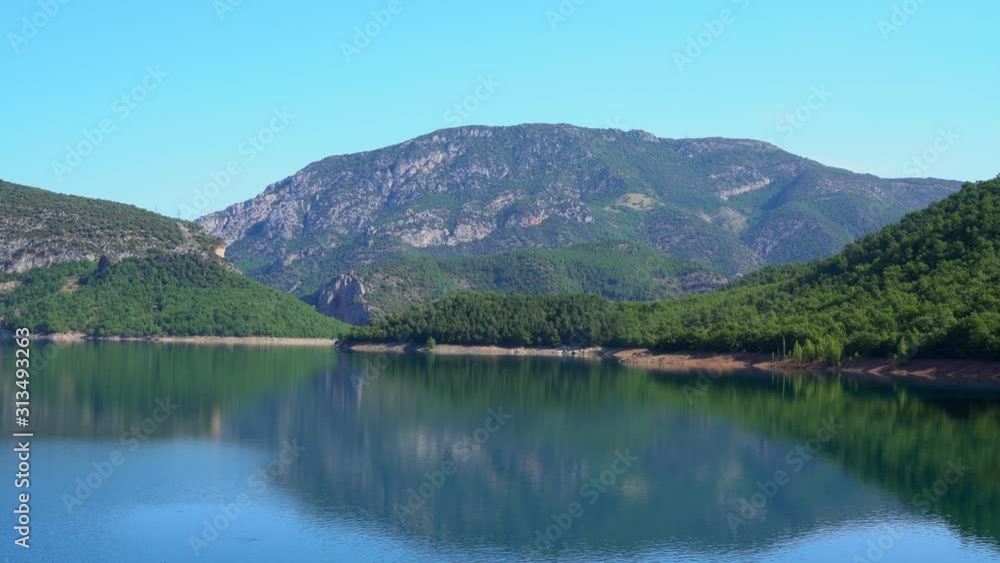 blue lake at the foot of the mountain near the forest on a sunny day blue lake at the foot of the mountain near the forest on a sunny day