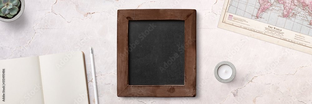 Fototapeta premium minimalistic style scene with chalkboard, notebook and a map on concrete background