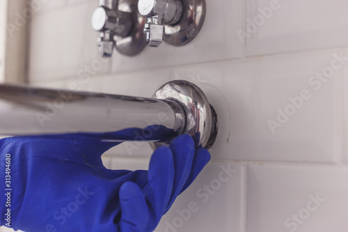 Fotografía Plumber maintains chrome universal escutcheon on siphon pipe under the washbasin