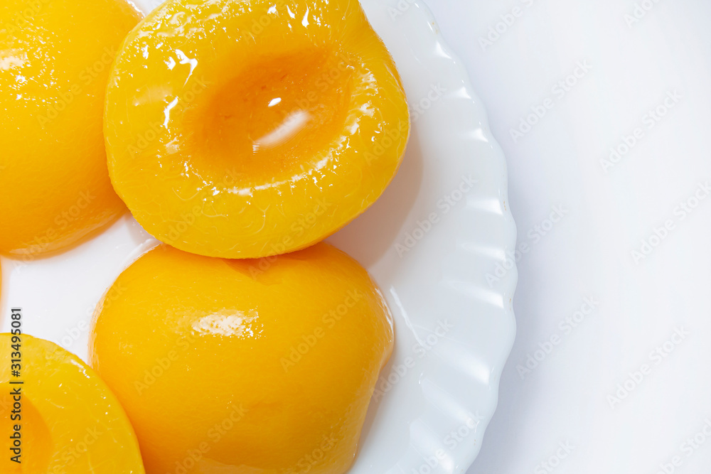 canned peaches on a white plate. Fruits on a white plate on a light background. close-up canned peaches on a white plate. Fruits on a white plate on a light background. close-up