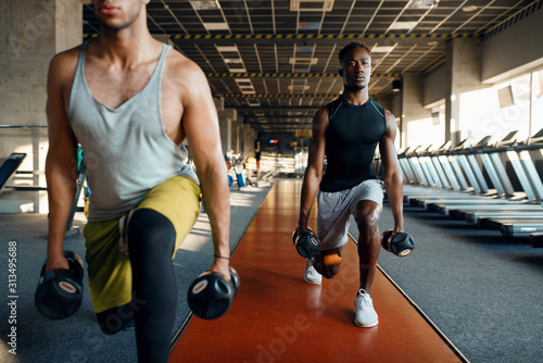 Two male persons doing exercise with dumbbells