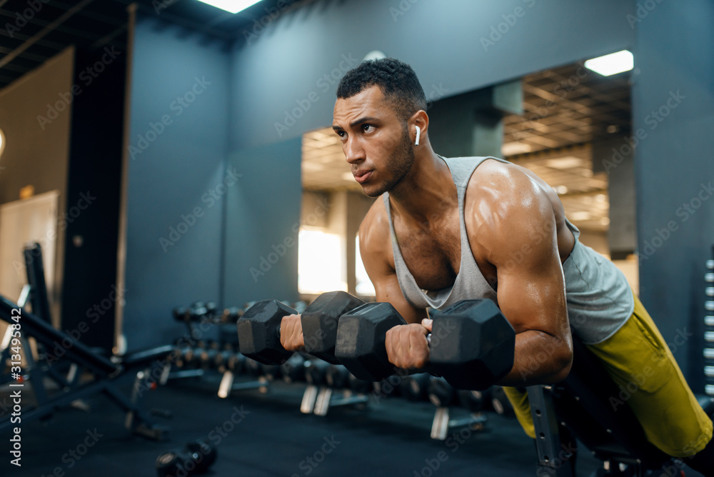 Man doing exercise with dumbbells on the bench Man doing exercise with dumbbells on the bench