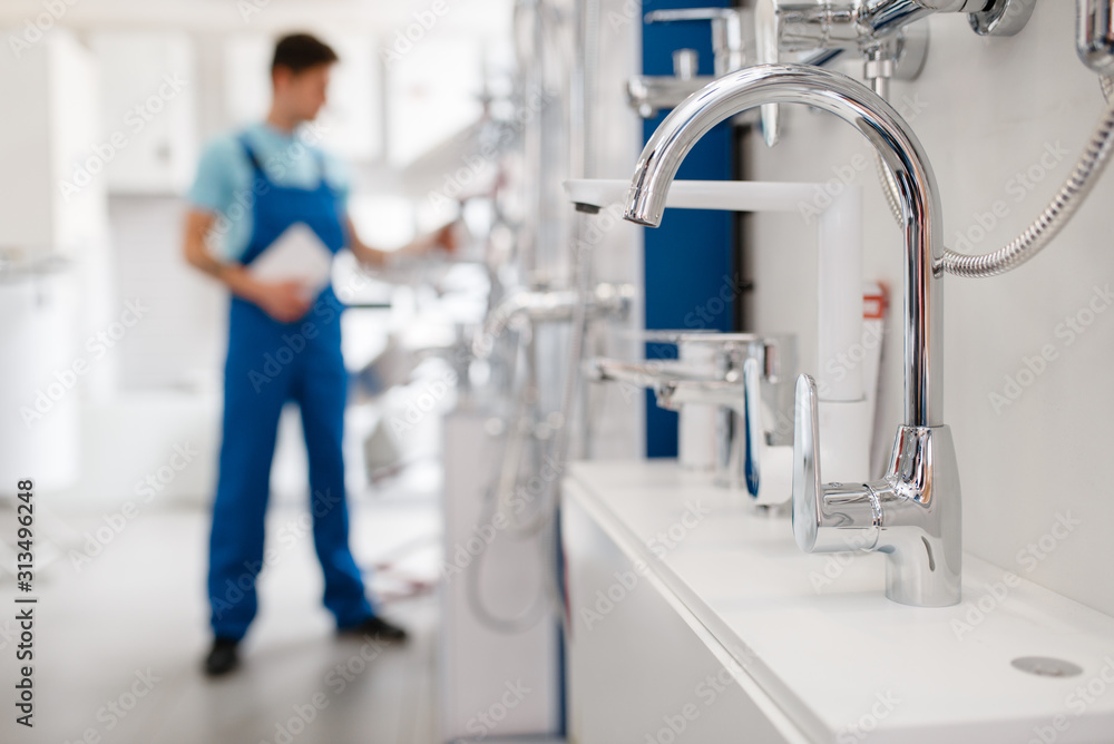 Plumber choosing faucet in plumbering store Plumber choosing faucet in plumbering store