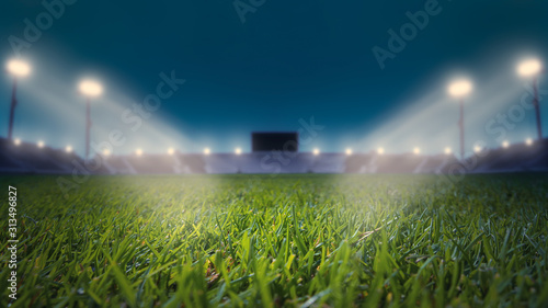 Soccer Stadium with Green Grass Field with Bright Floodlight Background.lights at night and football stadium