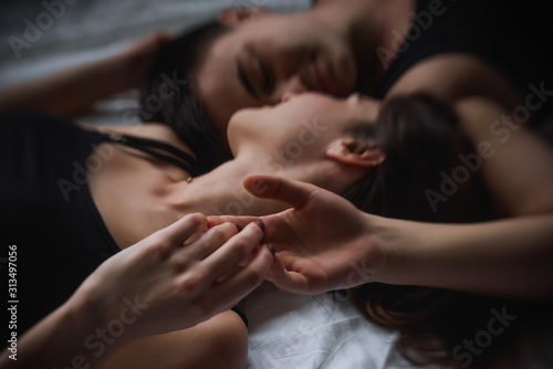 Defocused Top view of couple in love. Close-up portrait of the Lovers who lie on the bed at home, head to head. The morning of the newlyweds, tenderly resting on weekend at home. Concept of tactility