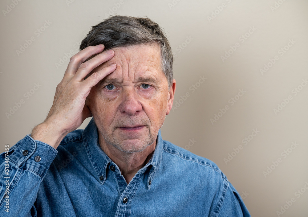 Head and shoulders portrait of a senior caucasian man with head in hands and looking depressed Head and shoulders portrait of a senior caucasian man with head in hands and looking depressed