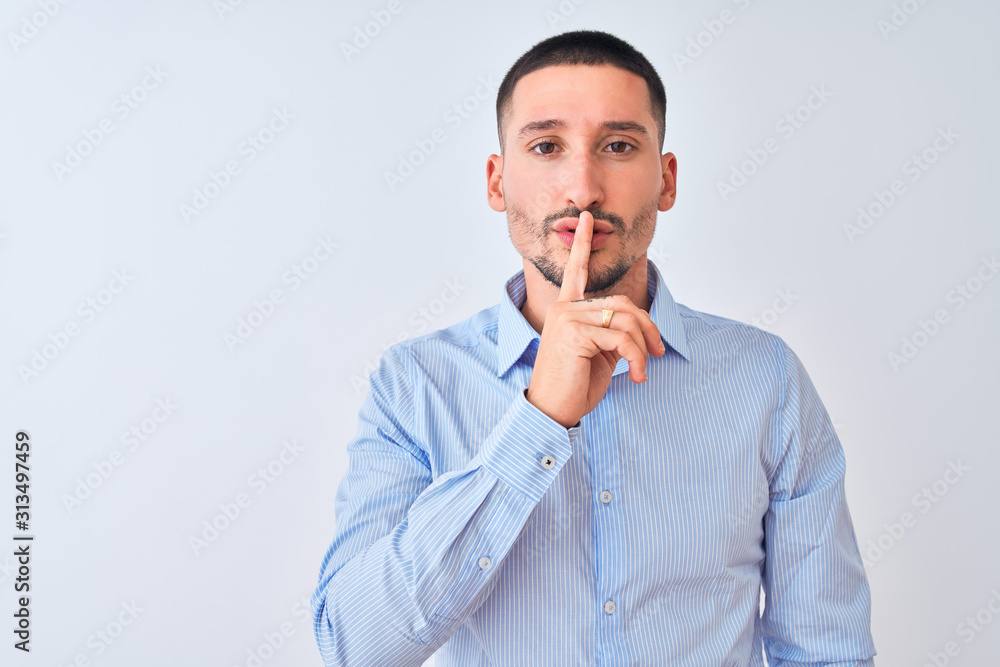 Young handsome business man standing over isolated background asking to be quiet with finger on lips. Silence and secret concept. Young handsome business man standing over isolated background asking to be quiet with finger on lips. Silence and secret concept.
