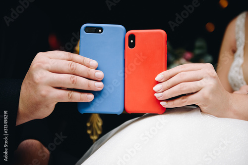 Wallpaper Mural Lovers holding two phones, blue and red, for Valentines day on 14 February Torontodigital.ca