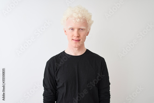 Young albino blond man wearing black t-shirt standing over isolated white background Relaxed with serious expression on face. Simple and natural looking at the camera.