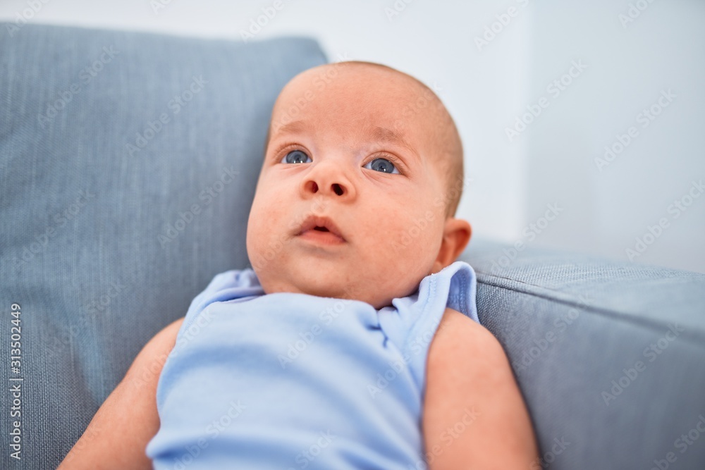 Adorable baby lying down on the sofa at home. Newborn relaxing and resting comfortable Adorable baby lying down on the sofa at home. Newborn relaxing and resting comfortable