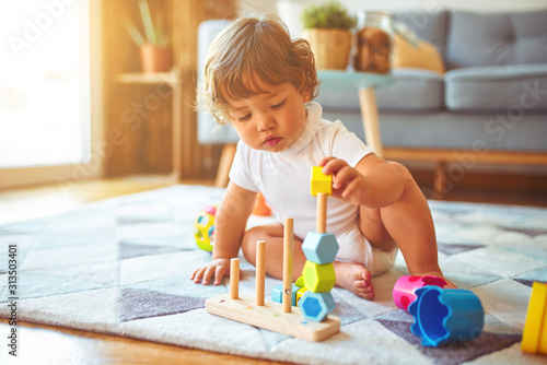 Beautiful toddler child girl playing with toys on the carpet