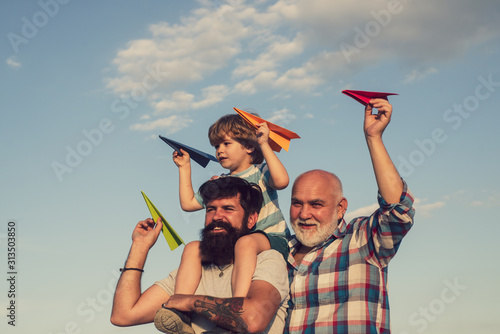 Fathers day - grandfather, father, son are hugging and having fun together.