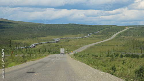 Truck on the Dalton Highway parralle to the Alyeska Trans Alaska Pipeline (TAPS) and pipeline access road near the Arctic Circle photo